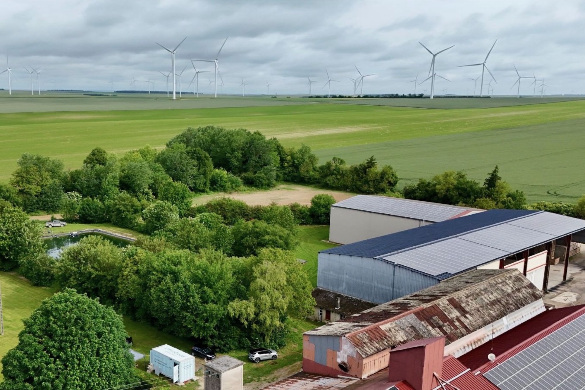 Bonne Voisine farm with agricultural buildings, photovoltaic roofs, wind turbines and the Policloud container